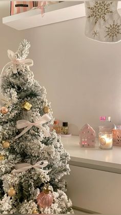 a white christmas tree with pink and gold ornaments