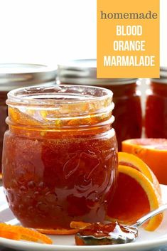 homemade blood orange marmalade in a glass jar with spoon on plate next to jam