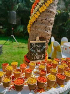 there is a sign that says shower the couple on it and many small cups filled with rice