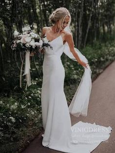 a woman in a white dress is walking down the road with her bouquet on her shoulder