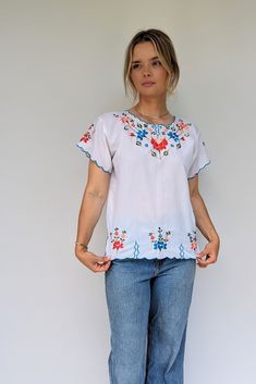 The vibrant floral embroidery makes this cool summer top! With blues, reds, oranges, pinks and greens and the sleeves are trimmed with the bright blue with a scalloped edging which repeats at the bottom hem with little faux slits.  Size: UK 10-12, Europe 38-40, US 6-8 Measurements: Bust 39 Inches, Bottom width 39 Inches Care: Cool machine wash Era: Est 70s Condition: Excellent vintage Brand: Linda of Mexico Material: Polyester