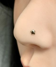 a close up view of the side of a woman's breast with a tiny nose piercing