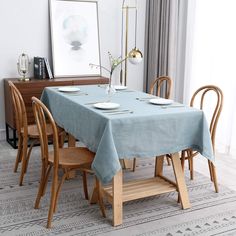 a dining room table with blue linens and wooden chairs