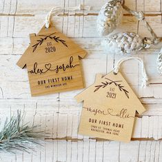 three wooden tags with the names of two different houses on them, hanging from twine strings