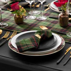 the table is set with black and green plaid napkins, silverware, and wine glasses