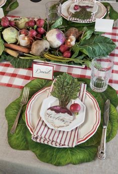 the table is set with fresh vegetables and place settings