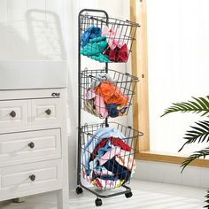 a metal rack with four baskets filled with clothes