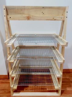 a wooden shelf with wire shelves on top of it and wood floors in front of the wall