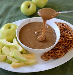 a plate with apples, pretzels and peanut butter