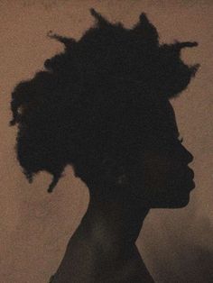 the silhouette of a woman's head is shown against a white wall with black hair