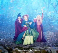 three women dressed as witches in the woods with text saying yes salem, we're back