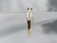 This sleek wedding band is set with a glittering row of square-cut, fine diamonds, in highly polished 14 karat yellow gold decorative squares. The look they create is very 'Deco', and very modern at the same time, this is a great piece for a wedding day or stacking ring.Metal: 14K Yellow Gold Gem: 9 Diamonds .42 Carats, J in Color, SI2 in ClarityWidth of Band: 3.7 mmHeight off Finger: 3.7 mmRing Size: 8.75 Marks: “14K 10-2-01 TC + PB” Stamped on the inside band Modern Formal Eternity Band With Single Cut Diamonds, Modern Gold Eternity Band With Brilliant Cut, Formal Square Cut Channel Set Jewelry, Elegant Gold Diamond Ring With Square Cut, Gold Square Cut Diamond Ring For Wedding, Gold Diamond Ring For Wedding With Square Cut, Emerald Cut Channel Set Eternity Band For Formal Occasions, Classic Square Wedding Rings, Classic Eternity Band With Princess Cut For Formal Occasions