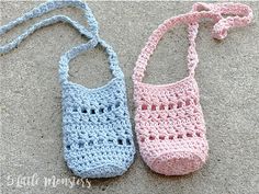 two crocheted purses sitting on the ground next to each other, one pink and one blue