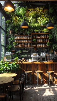 an indoor cafe with plants growing on the wall and wooden tables in front of it