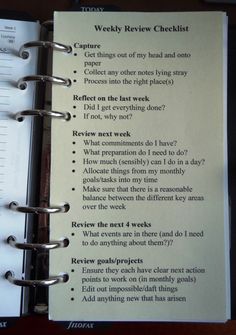 an open spiral notebook with some writing on the page and a list attached to it that says weekly review checklist