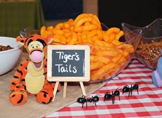 a table topped with lots of food next to a sign that says tiger's tails