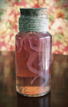 a jar filled with liquid sitting on top of a wooden table