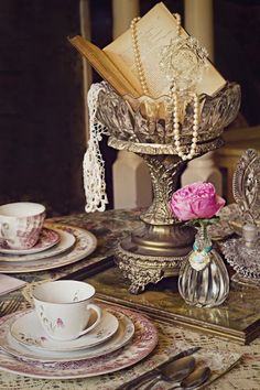 the table is set with dishes, cups and saucers