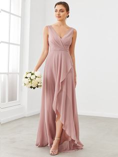 a bridesmaid in a pink dress holding a white bouquet and standing next to a window