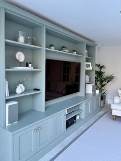 a living room filled with furniture and a flat screen tv on top of a wooden entertainment center