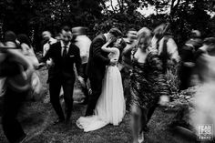 black and white photograph of bride and groom surrounded by people