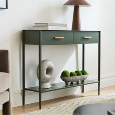 a green console table with two bowls of broccoli and a lamp on top