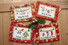 four red christmas placemats with stockings and bells on them