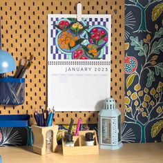 a desk with a calendar, pens and pencils on it