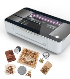 an image of a printer and some other items on a white surface with the machine in view