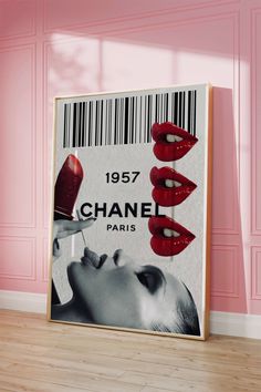 a poster with red lips on it in front of a pink wall and wooden floor