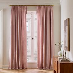 a living room with a large window and pink curtains