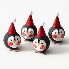 three penguin figurines with red hats on them