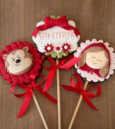 three decorated lollipops on sticks with red bows