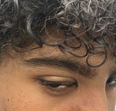 a close up of a man's face with frizz on his hair