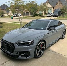 a grey car parked in front of a house