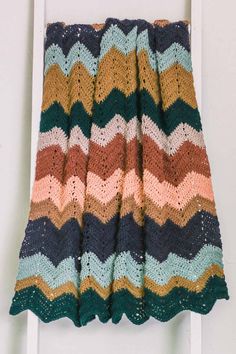 a crocheted blanket hanging on the side of a door