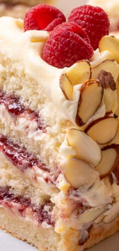 a piece of cake with white frosting and raspberries on top