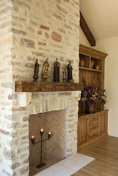 a stone fireplace in a living room with wood flooring