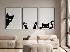 three black cats are hanging on the wall