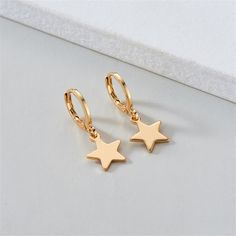 Celestial-inspired charms dangle from these huggie earrings boasting timeless shine with 18k gold-plated metal. 0.39" W x 0.91" L 18k gold-plated copper Trendy Gold Earrings With Star Charm, Rose Gold Hypoallergenic Dangle Huggie Earrings, Trendy Gold Hoop Earrings With Star Charm, Elegant Gold Hoop Earrings With Star Charm, Gold Hoop Earrings With Star Charm For Gift, Gold Hoop Earrings With Star Charm As A Gift, Everyday Gold Star Huggie Earrings, Rose Gold Star Charm Earrings, Rose Gold Star Earrings With Star Charm