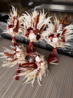 two bouquets of dried flowers are sitting on a table