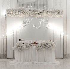 an elegant wedding setup with white flowers and chandelier