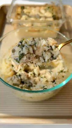 a spoon full of food sitting on top of a glass bowl filled with rice and broccoli