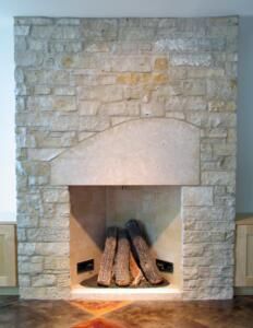 a stone fireplace with logs in it