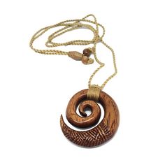 Koa Wood Koru style (Swirl) necklace with natural brown cord. Features engravings on face of pendant. A feel good and give good vibe necklace. The spiral form is a Koru, which is the fern frond as it opens bringing new life and purity to the world. The closed outer circle is the circle of life. It also represents peace, tranquility, spirituality, family as well as regrowth or new beginnings/journey. Material: Koa Wood Koru / Swirl Natural Cord: Adjustable Pendant Size: 1-5/8" x 1-5/8" Spiral Form, Turtle Carving, Swirl Necklace, Hawaiian Sea Turtle, Fern Frond, Throne Room, Koa Wood, The Spiral, Classy Tattoos