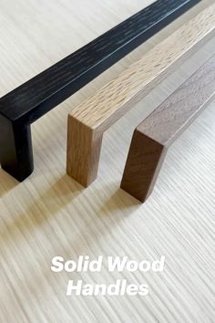 a wooden bench sitting on top of a hard wood floor next to two black handles