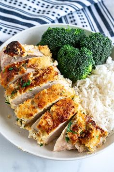 chicken, rice and broccoli on a plate with a blue and white napkin