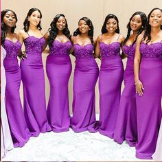 a group of women standing next to each other in long purple dresses with flowers on them