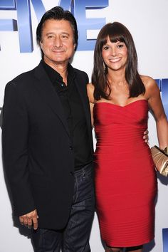 a man and woman standing next to each other on a red carpet at an event