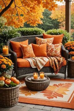 an outdoor living room with orange and brown decor on the outside, surrounded by fall foliage